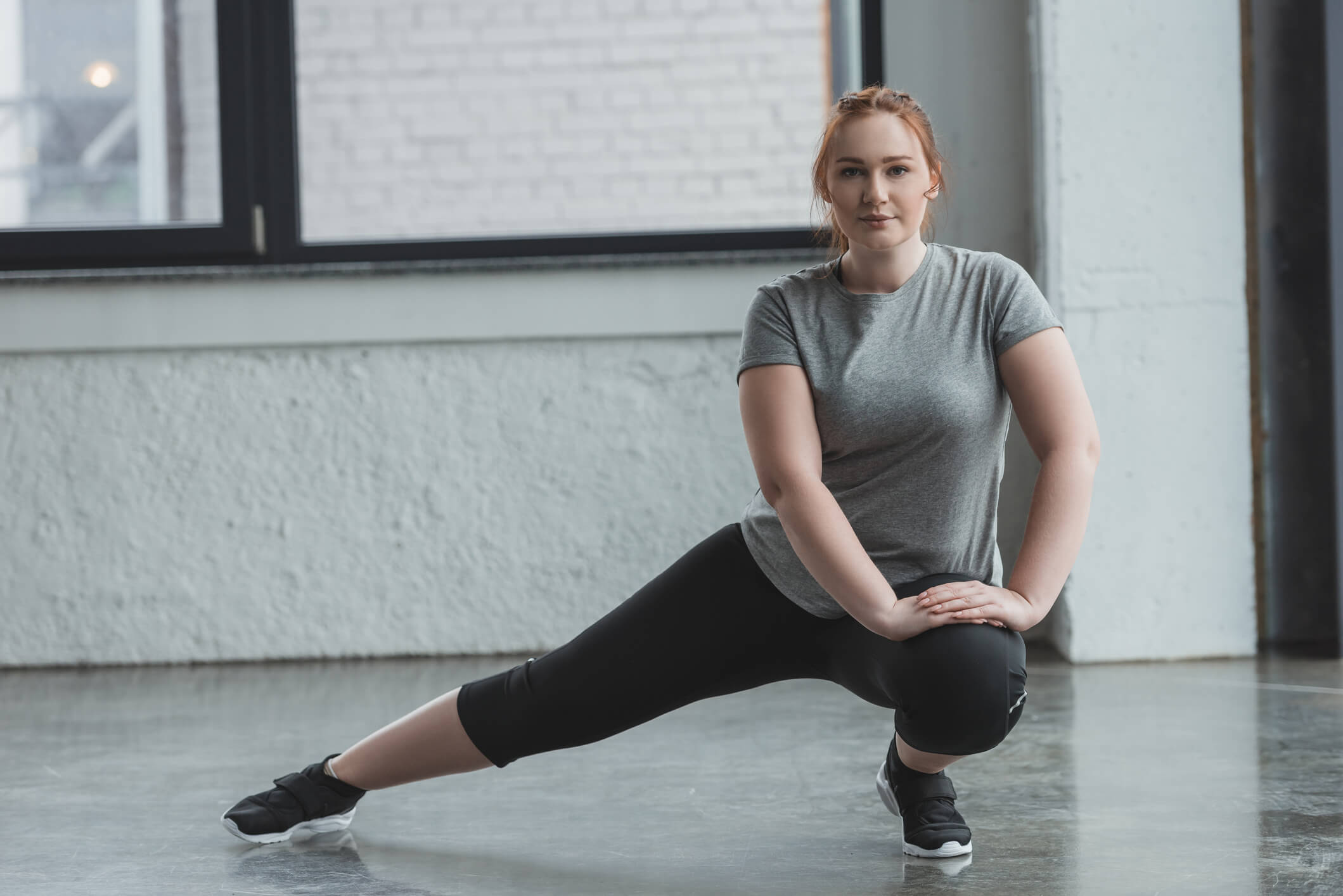 Woman in athletic clothes stretching to one side Woman in athletic clothes stretching to one side