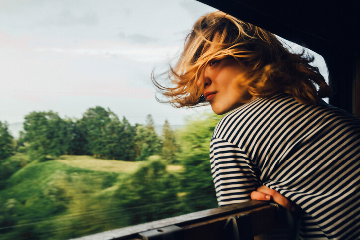 Woman leaning out window to look at view Woman leaning out window to look at view
