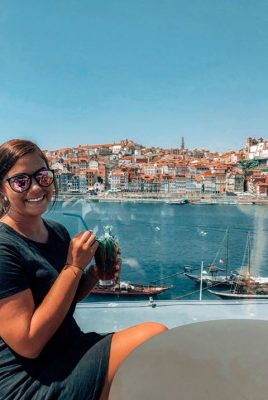 Smiling woman with drink and beautiful background of water and buildings Smiling woman with drink and beautiful background of water and buildings