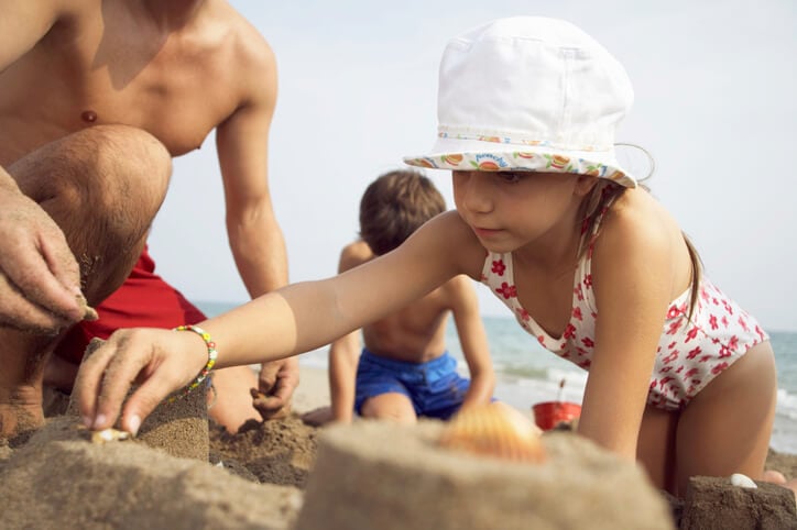 close up two kids building sandcastle with dad close up two kids building sandcastle with dad