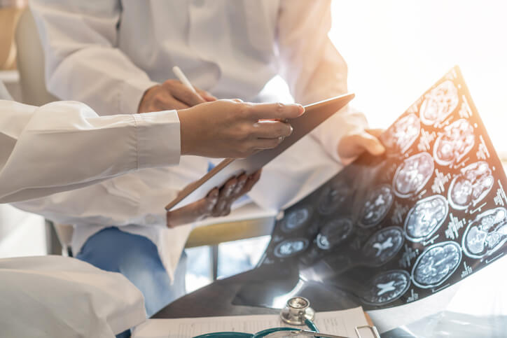 Doctors technician looking at x-ray of brain Doctors technician looking at x-ray of brain