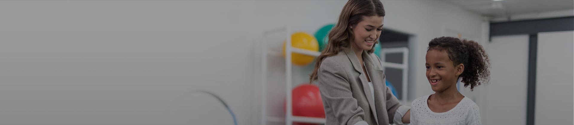 Physical therapist providing care to child in therapy gym