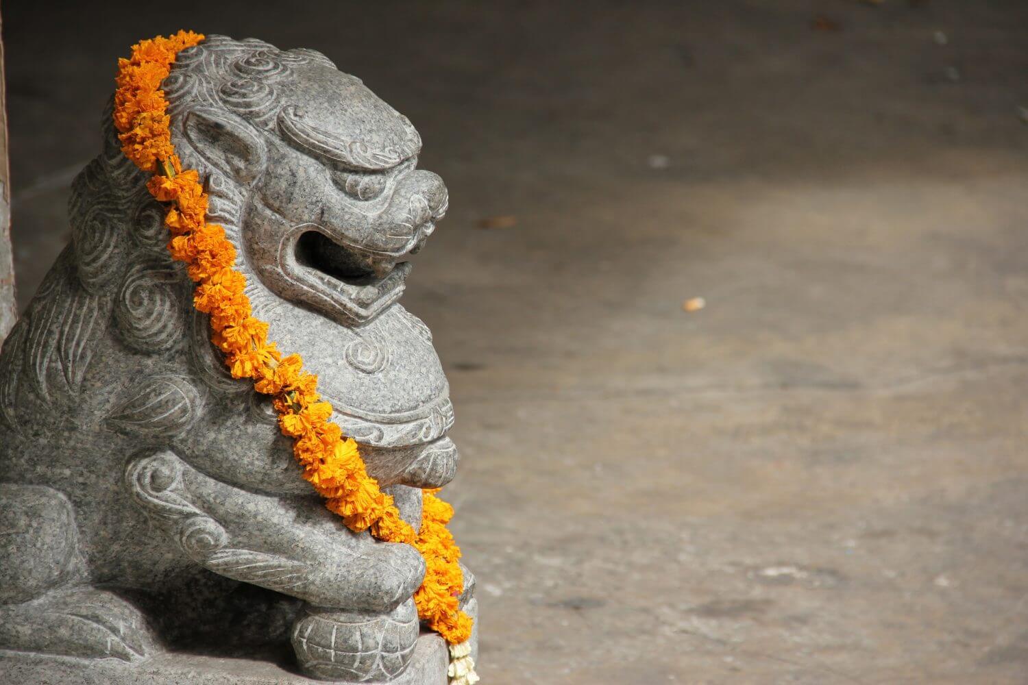 Gargoyle statue with lei of marigolds Gargoyle statue with lei of marigolds