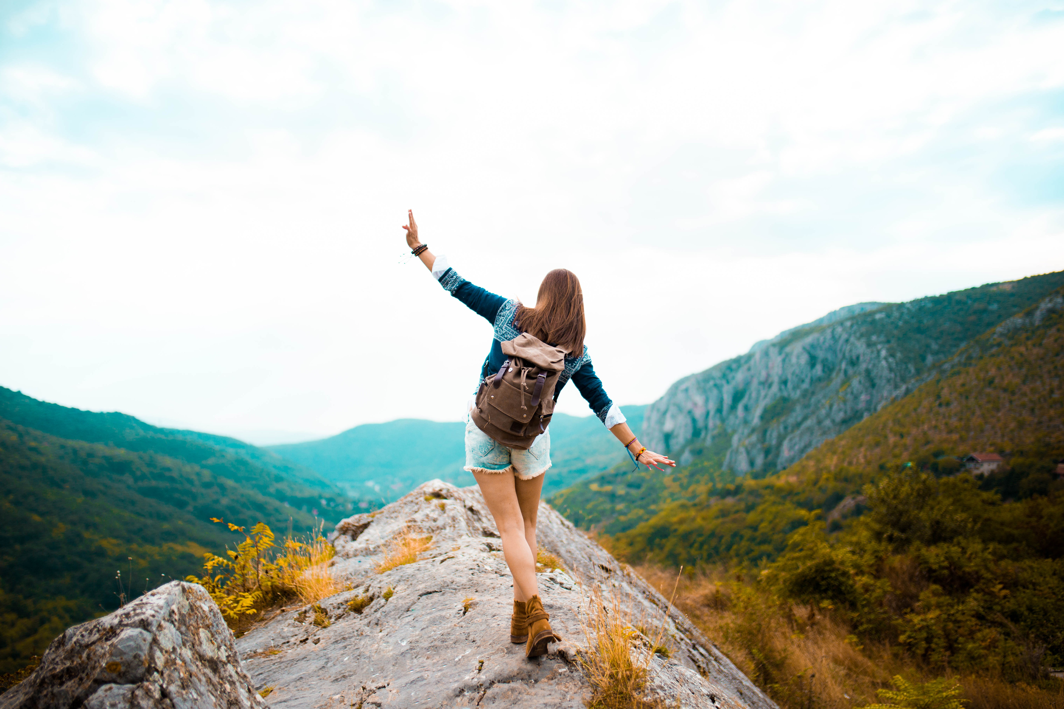 female traveler balances walking across mountain peak female traveler balances walking across mountain peak