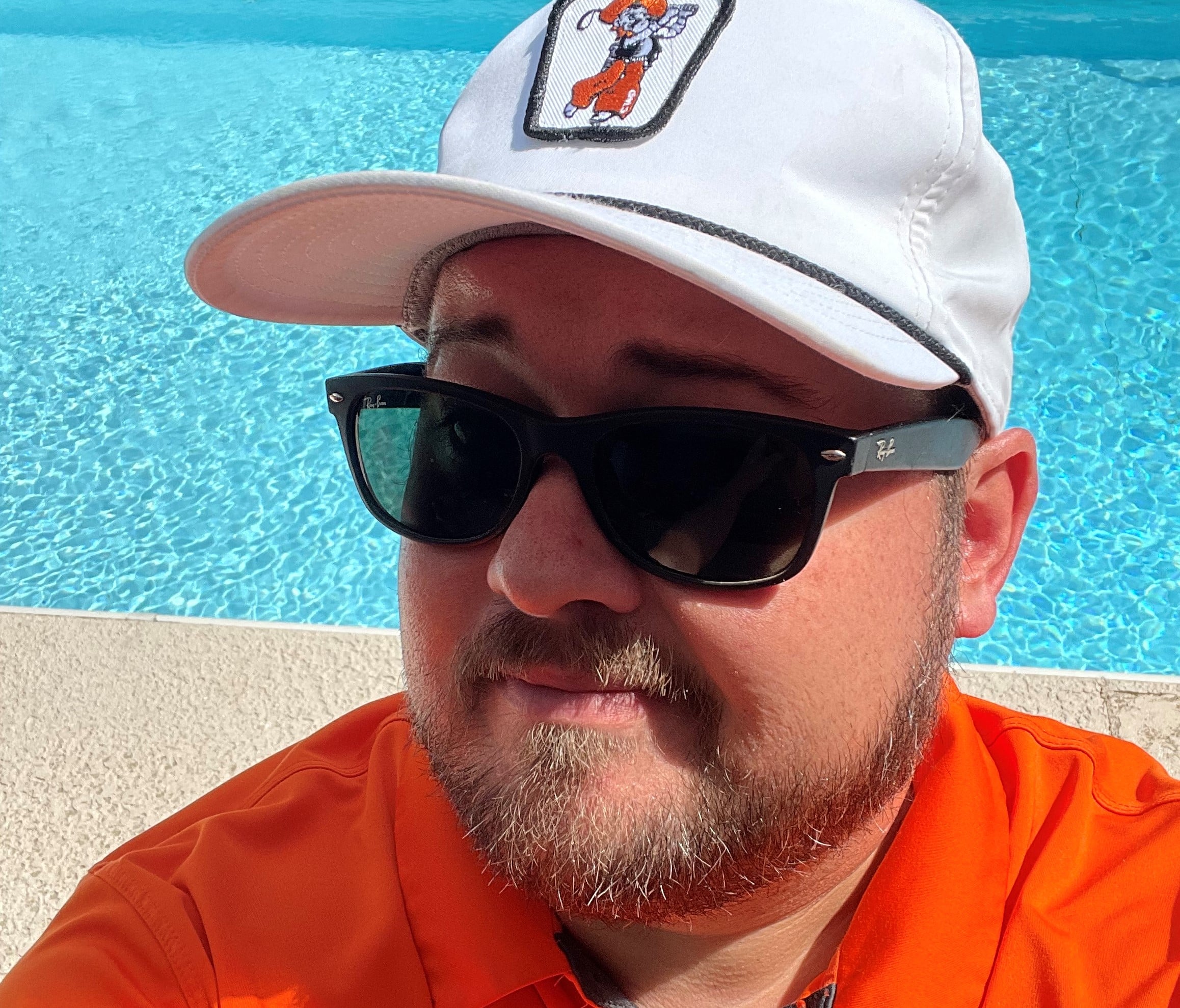 man in raybans smiling next to pool man in raybans smiling next to pool