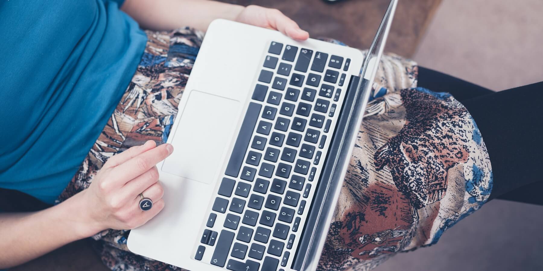 woman typing on laptop on her lap woman typing on laptop on her lap