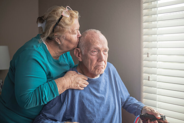 Caregiver kissing elderly man on head Caregiver kissing elderly man on head
