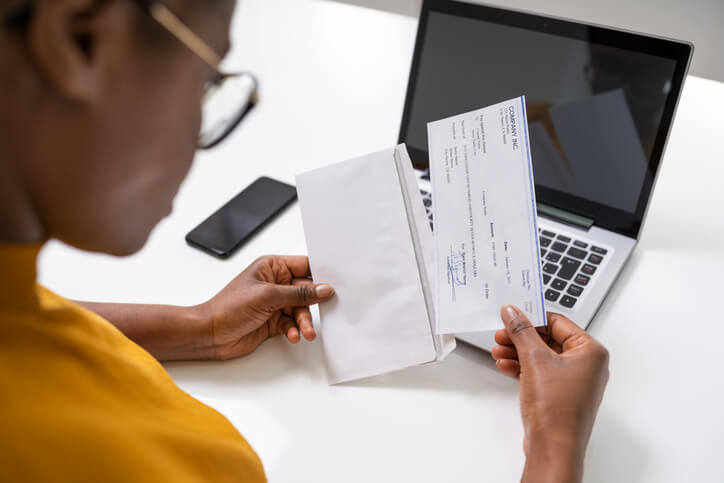 Woman holding paycheck Woman holding paycheck