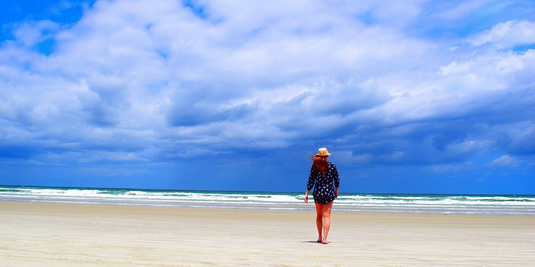woman walking empty sand with big sky woman walking empty sand with big sky