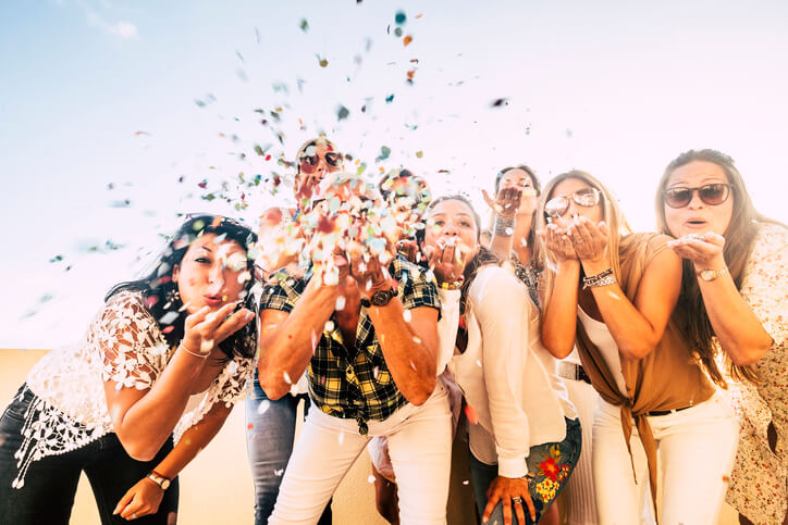 group celebrating with confetti and blowing kisses group celebrating with confetti and blowing kisses