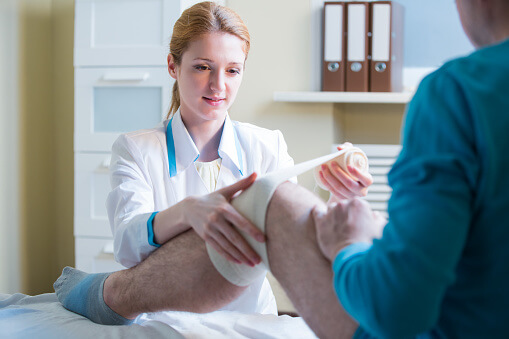 physical therapist working with patient's leg physical therapist working with patient's leg