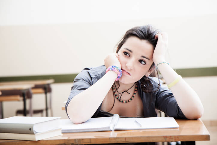 Distracted teenager with schoolwork Distracted teenager with schoolwork