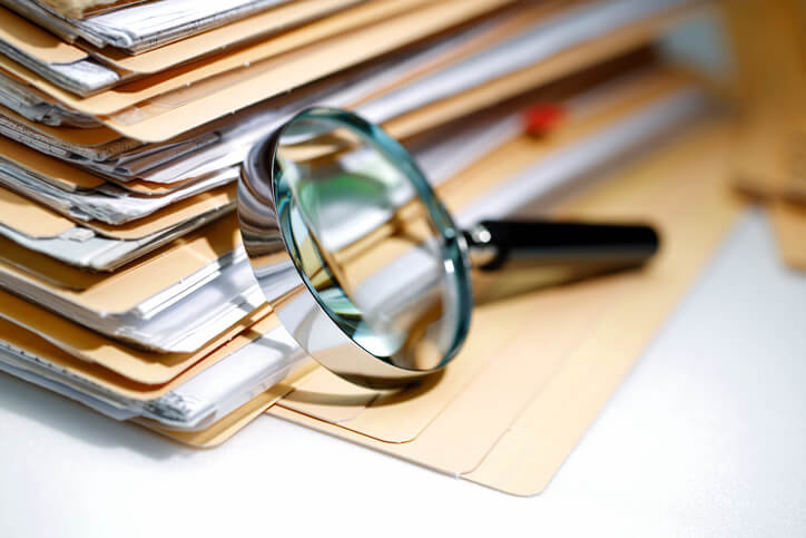 Magnifying glass with stack of files Magnifying glass with stack of files