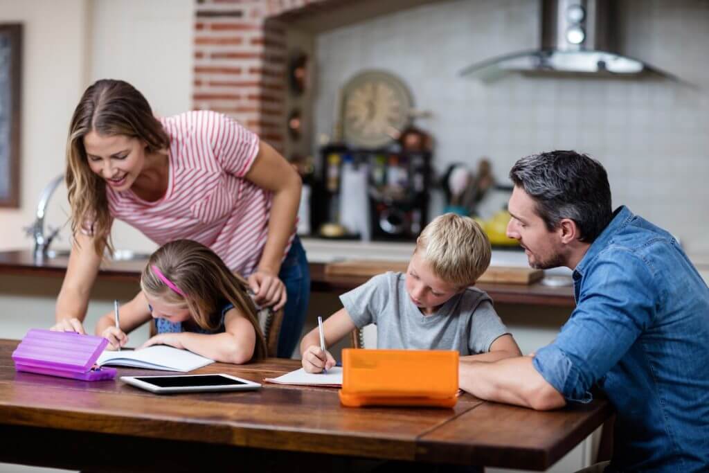 Two parents helping two children with homework Two parents helping two children with homework