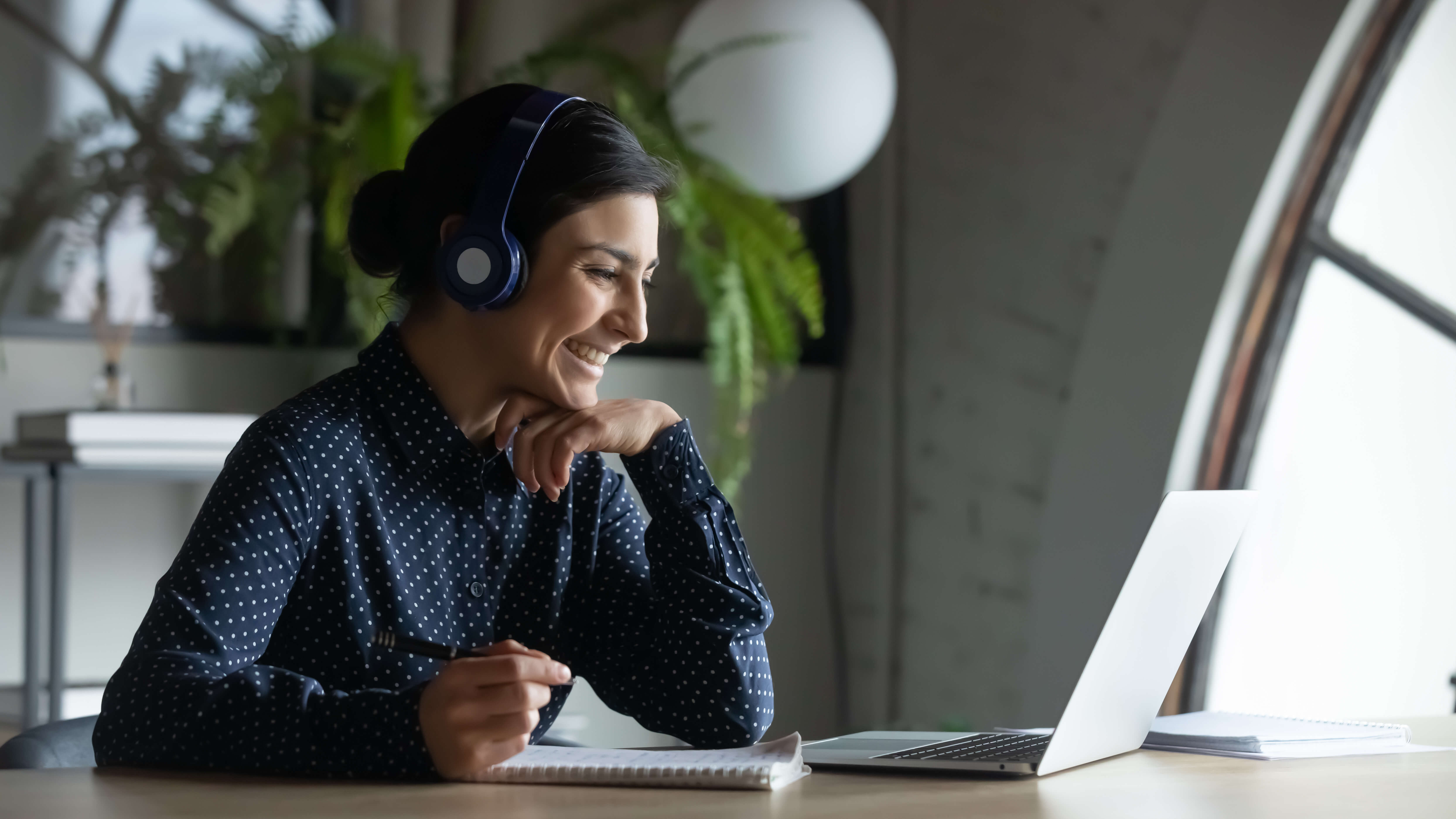 Woman with headset smiling at laptop Woman with headset smiling at laptop