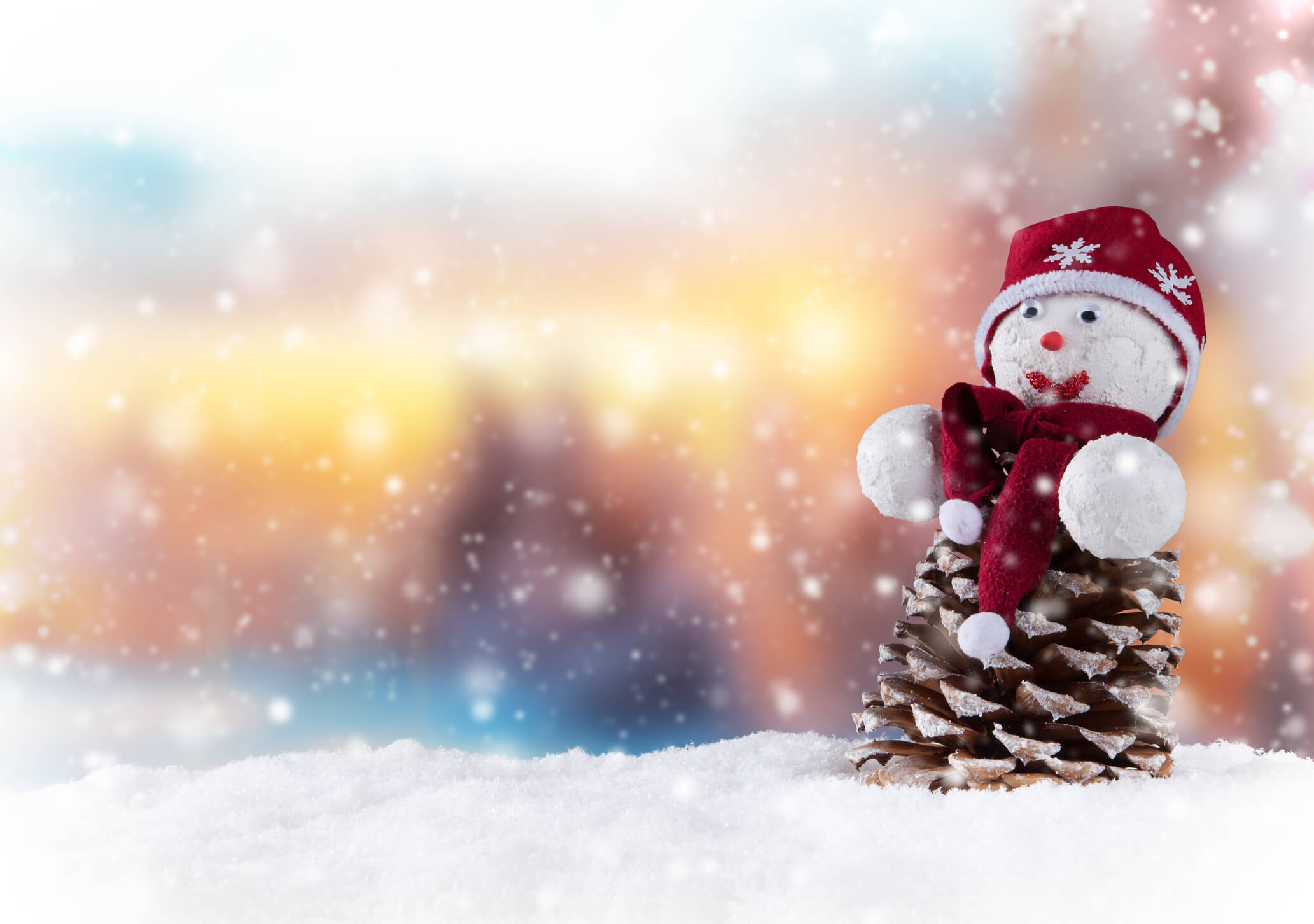 Scene of snow with snowman made out of pinecone on right side of frame Scene of snow with snowman made out of pinecone on right side of frame