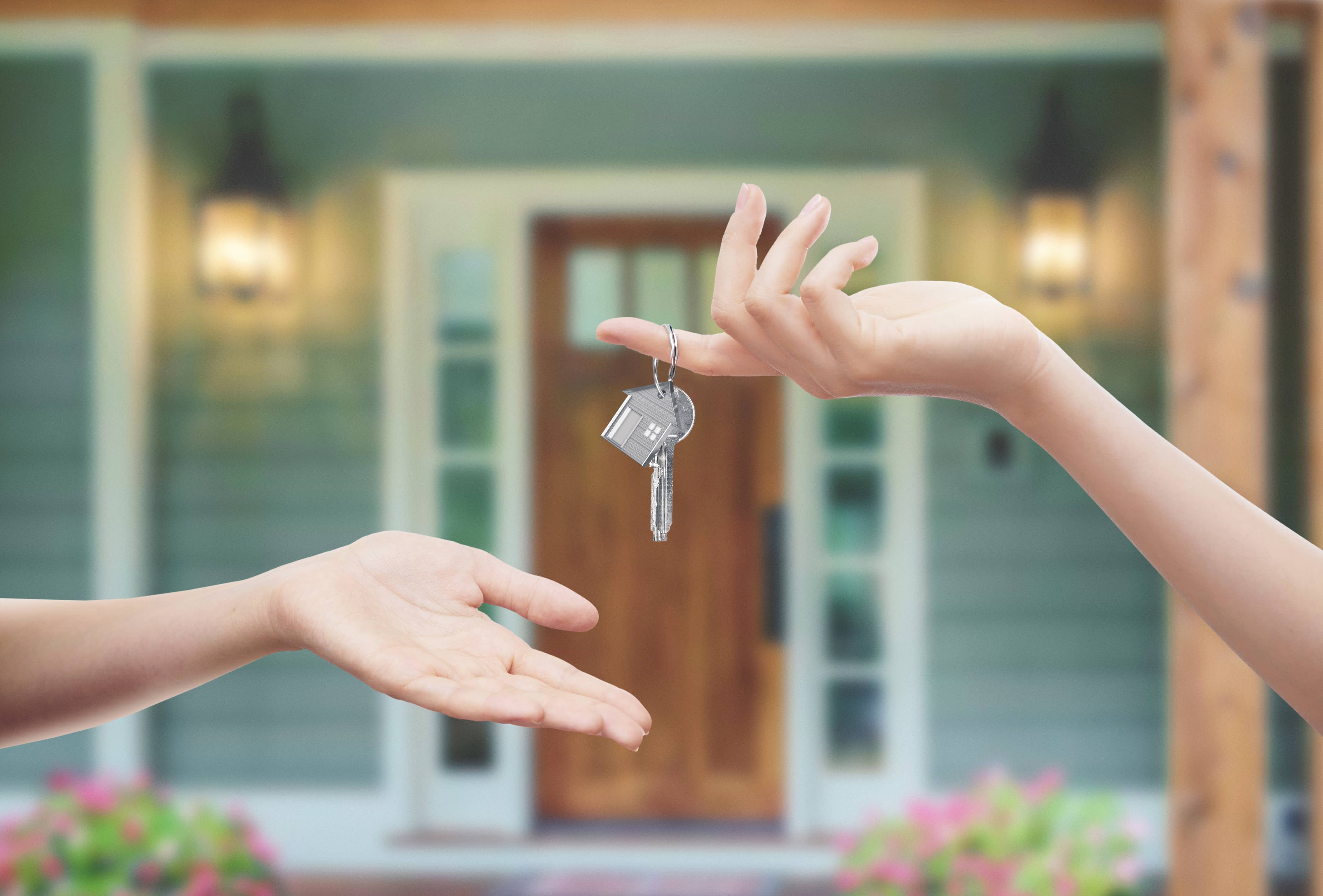 House key changing hands in front of home House key changing hands in front of home