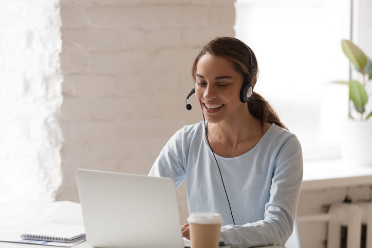 Woman on headset looking at laptop Woman on headset looking at laptop