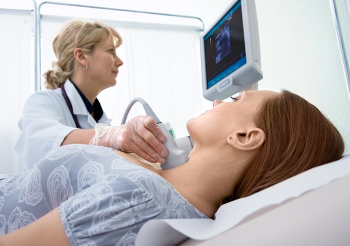 Sonographer using machine on patient's throat Sonographer using machine on patient's throat