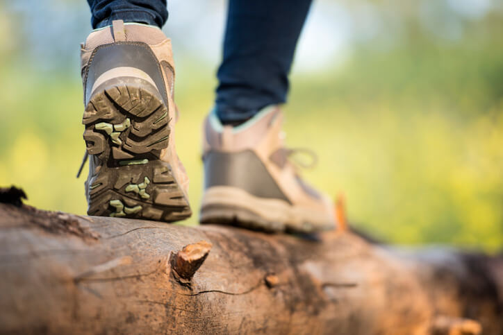 close up of woman's hiking boots on log close up of woman's hiking boots on log