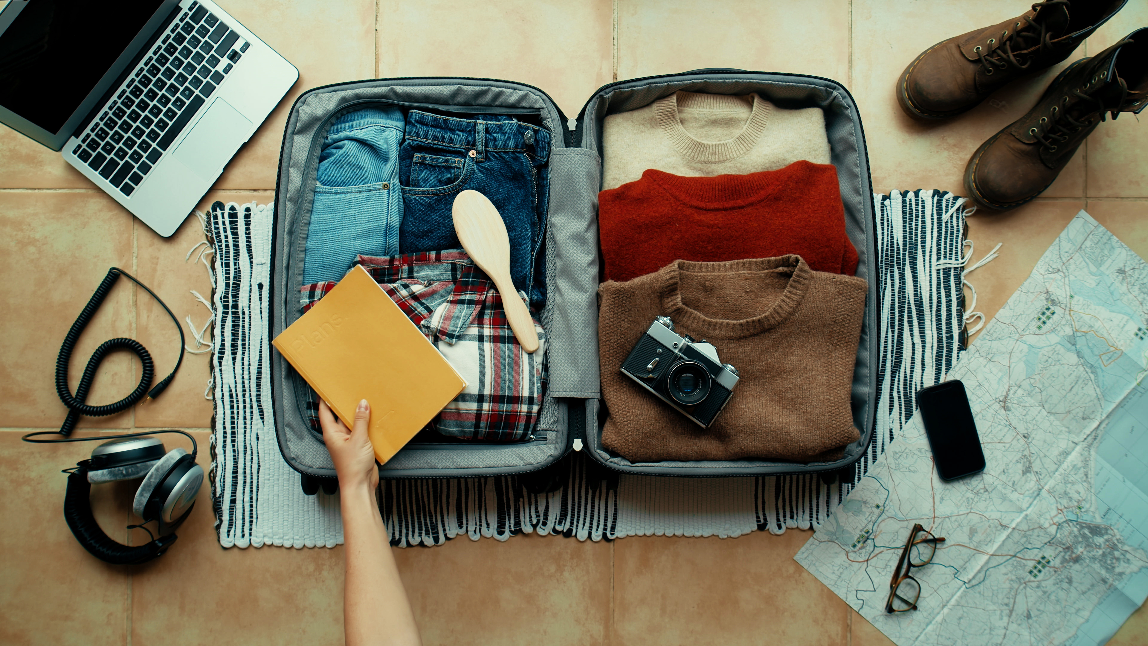 collage style layout of travel packing essentials in suitcase collage style layout of travel packing essentials in suitcase