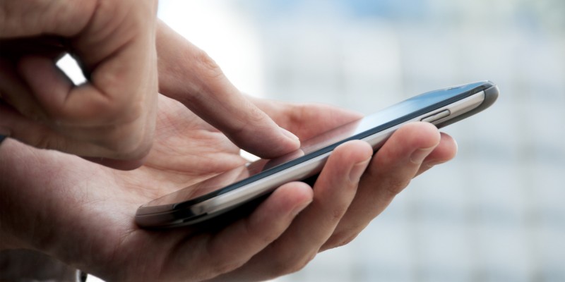 Finger touching a smart phone Finger touching a smart phone