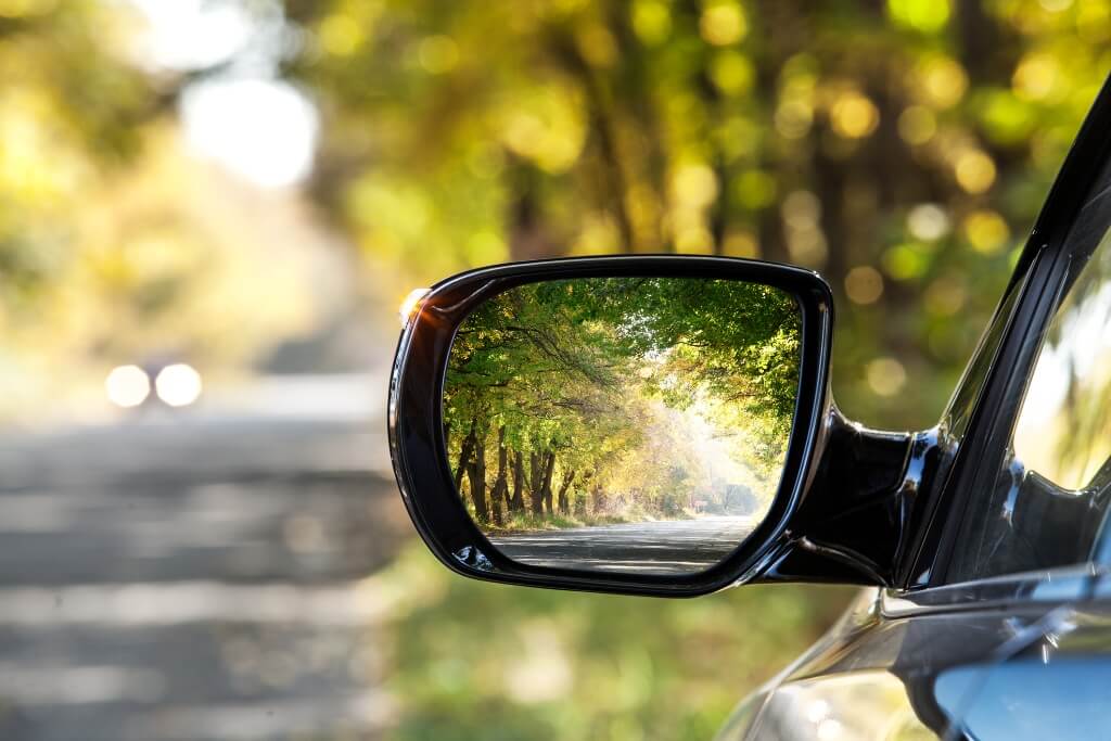Tree lined road seen in car's side mirror Tree lined road seen in car's side mirror