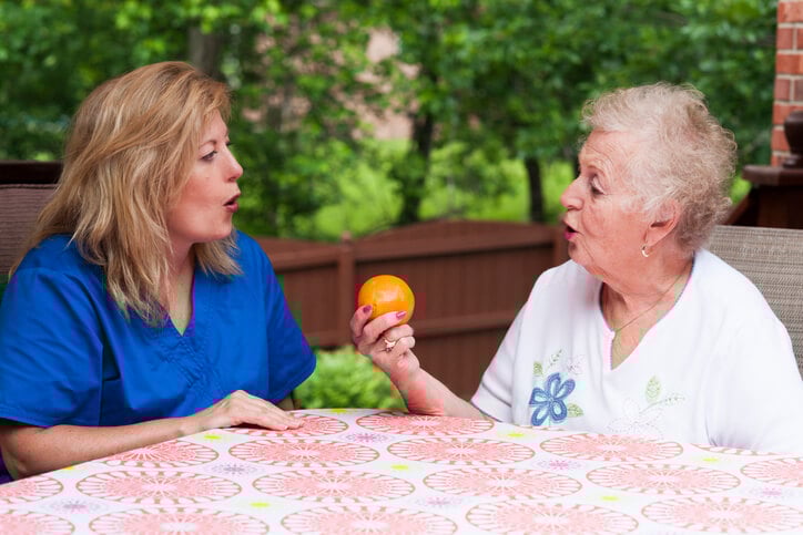 SLP working with senior patient to say orange SLP working with senior patient to say orange