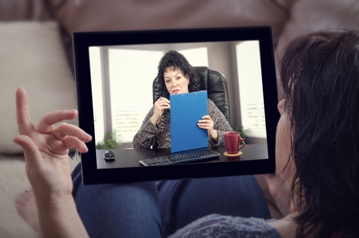 Woman having remote therapist appointment on tablet Woman having remote therapist appointment on tablet