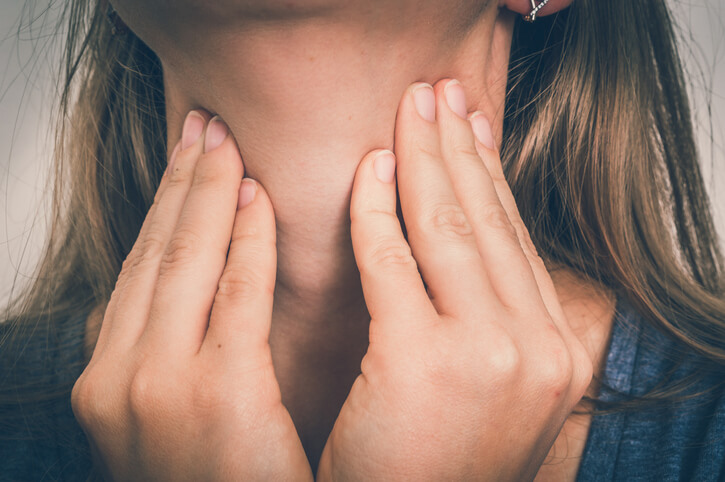 Woman holding her throat Woman holding her throat