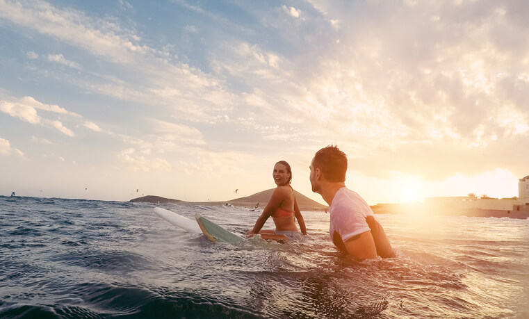 Couple sitting on surfboards in ocean Couple sitting on surfboards in ocean