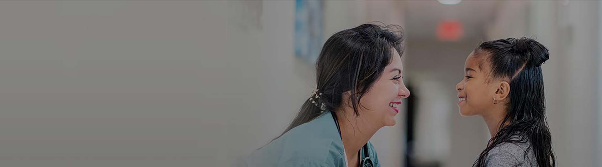 A female doctor smiling at a young female patient