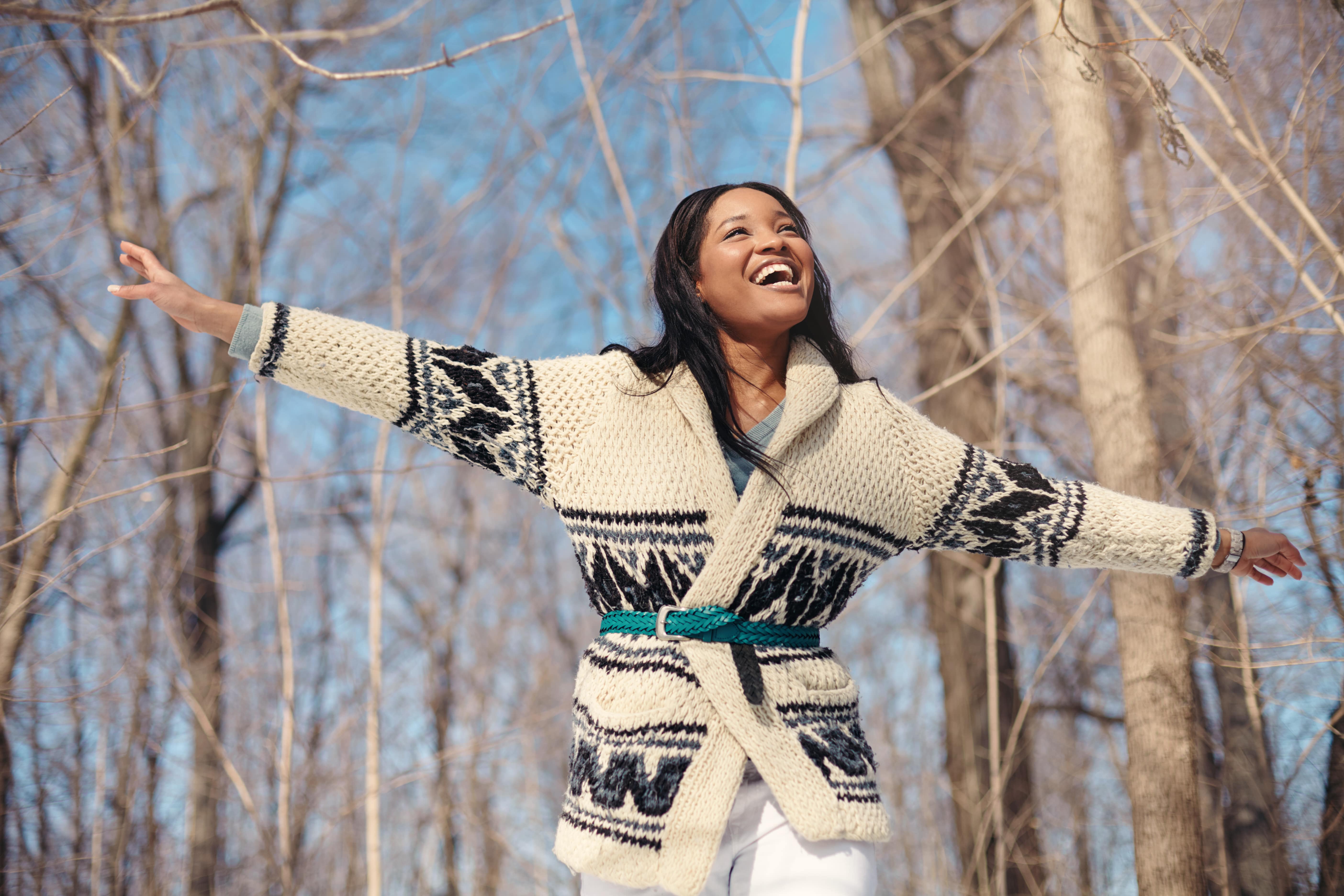 beautiful young smiling female traveler stands with arms out