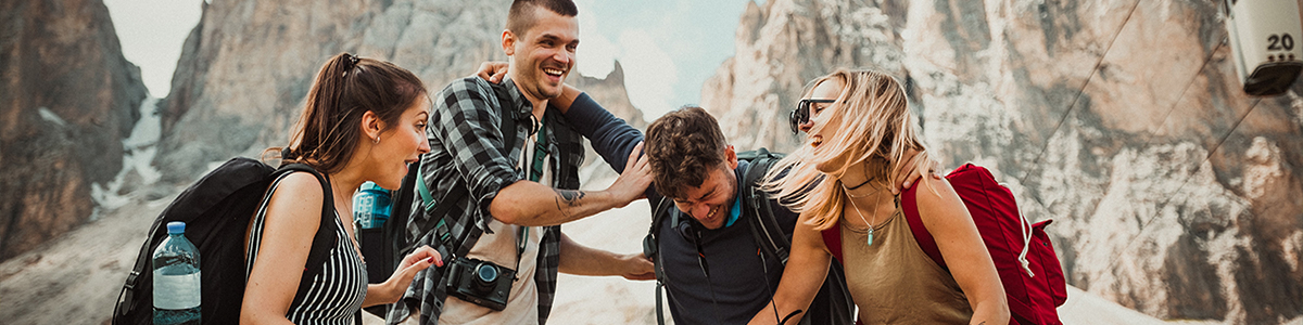 Two men and two women laughing together while hiking
